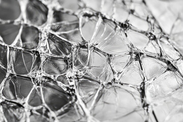 Macro shot of shattered glass texture, intricate web of cracks forming complex geometric patterns.