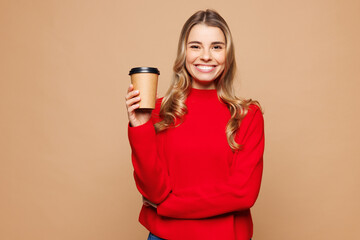 Poster - Young smiling Caucasian woman she wear red casual clothes hold takeaway delivery craft paper brown cup coffee to go isolated on plain pastel light beige background studio portrait. Lifestyle concept.