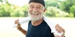 © Rawpixel.com - Elderly man smiling outdoors, holding a towel. Happy elderly man enjoying nature. Elderly man with a cap, relaxed and cheerful in a sunny park setting. Happy elderly man smiling and exercising.