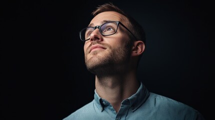 Wall Mural - Man in Glasses Looking Upward on Black Background