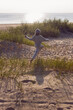 © saulich84 - A fashionable seven-year-old boy runs along a sandy beach by the sea in autumn in a sweater and hat at sunset.