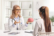 © Ljupco Smokovski - Female neurologist doctor holding a brain model and talking to a woman