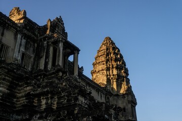 Wall Mural - View of Angkor Wat temple against a clear blue sky, showcasing ancient architecture