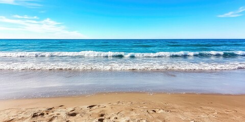 Wall Mural - Sunlit sandy beach with clear blue ocean and gentle waves under bright sky