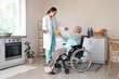 © Pixel-Shot - Physical therapist and senior woman in wheelchair massaging her hands with ball at home
