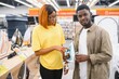 © Serhii - African american Couple standing in an electronics store choosing an electric iron for Ironing things, household chores