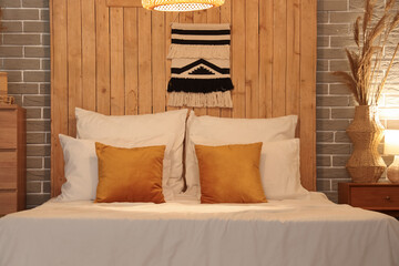 Wall Mural - Comfortable bed with pillows and glowing lamp in interior of bedroom