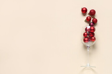 Wall Mural - Wine glass with Christmas baubles on beige background