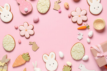 Wall Mural - Frame made of eggs, decor and different Easter cookies on pink background