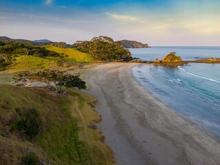 Wall Mural - Coastal scene with photographers capturing the beauty of a secluded beach. Tranquil morning light bathes the shoreline. Elliot Bay, Rawhiti, Northland, New Zealand