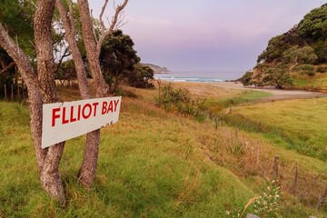 Wall Mural - Elliot Bay sign, overlooking the beach and ocean waves. Scenic coastal view. Elliot Bay, Rawhiti, Northland, New Zealand