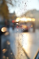 Poster - Rain Drops on a Window Pane with Blurry Background During Sunset Light : Generative AI