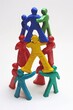 © HISTOCK - Colorful wooden figures standing on each other's shoulders