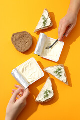 Wall Mural - Philadelphia cheese in a plastic package with sandwiches, on an orange background.