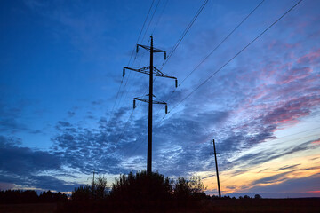 Wall Mural - sunset over forest. silhouette of a high voltage pole against the sunset. sky and clouds.