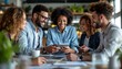 © mhmdyatt - Smiling Diverse Team Using Tablet in Casual Office Meeting Space