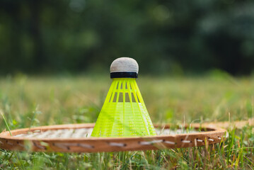 Wall Mural - Neon yellow badminton shuttlecock and racket on green grass outdoors. Copy space soft selective focus on shuttlecocks. Alternative fitness recreational sport