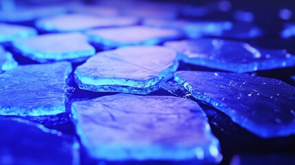 Wall Mural - Blue illuminated ice shards scattered on a dark surface, creating a serene and cool atmosphere