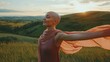 © javier - Young bald woman with cancer spreads her arms on a windy park hilltop