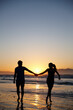 © peopleimages.com - Couple, silhouette and holding hands at beach, sunrise and care with bonding for love on valentines day. People, partnership and support by waves, ocean or outdoor with mockup space in New Zealand