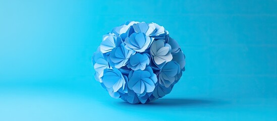 Poster - Spherical blue and white origami floral ball centered on vibrant light blue background showcasing kusudama art with soft shadows for depth