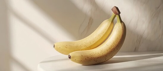 Poster - Ripe yellow bananas resting on a light-colored surface with soft shadows cast by natural light creating a warm, inviting atmosphere.