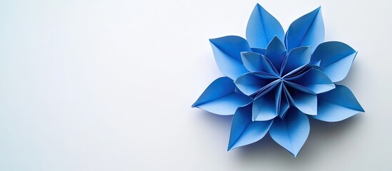 Poster - Blue origami flower with varying shades of blue positioned on the right side against a clean white background showcasing intricate paper folding techniques.