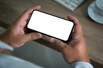 Wall Mural - a smart person is using a laptop and smartphone at a modern office desk, holding a phone in one hand