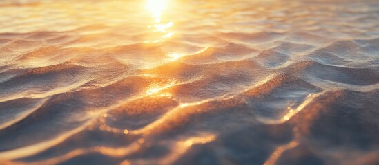 Fototapete - Golden sunrise reflecting on gentle sandy ripples creating a tranquil beachfront scene with warm orange and soft golden hues in the foreground.