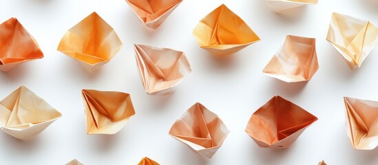 Aufkleber - Array of assorted origami boats in warm tones of orange and beige on a clean white background, creating a harmonious and artistic composition.