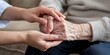 © hobonski - Compassionate Hands Holding Elderly's Hands. A caregiver gently holds the hands of an elderly person, symbolizing compassion, support, and connection in a caring and nurturing environment.
