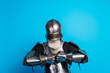 © deagreez - A senior man dressed in medieval armor adjusts his gauntlet against a vibrant blue backdrop, portraying bravery and historical essence.