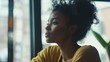 © @_ greta - Contemplative African American Woman Gazing Out Window with Peaceful Expression