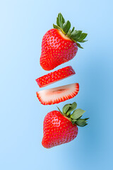 Wall Mural - Sliced strawberry floating vertically in mid-air, isolated on a white background