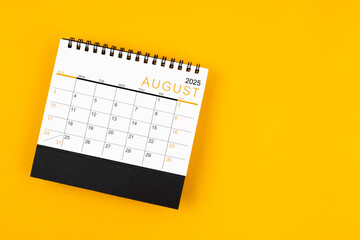 Wall Mural - August 2025 desk calendar on yellow background, position with copy space.