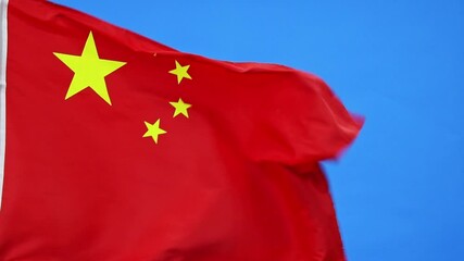 Wall Mural - Chinese flag waving on blue sky background, slow motion video