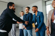 © Jacob Lund - Diverse professionals in a corporate office greeting each other with a handshake