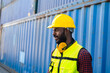 © Jack Tamrong - Black man worker with safety helmet working in container shipyard for import export distribution logistic