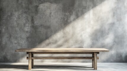 Canvas Print - Rustic wooden table against a textured concrete wall, sunlit.