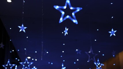 Wall Mural - a room with a lot of stars hanging from the ceiling. the stars are lit up and create a festive atmos
