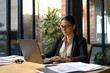 © Macrostock - Focused professional financial it specialist latin hispanic business lady working concentrated on laptop pc sitting in office. Middle eastern indian woman using computer technology app for work online