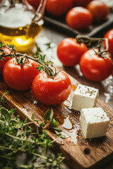 Wall Mural - Fresh tomatoes on a wooden board with feta cheese and herbs
