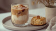 © Martina - Aesthetic shot of layered iced coffee with pecans and a sweet biscuit on a speckled plate.