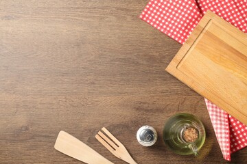 Wall Mural - Checkered tablecloth, cooking utensils, oil and spice on wooden table, flat lay. Space for text