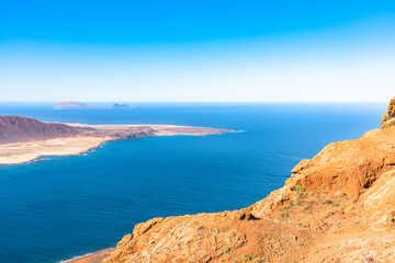 Wall Mural - Unique panoramic magnificent aerial view of volcanic islands La Graciosa north cape, Allegranza in Atlantic ocean, from Mirador del Rio, Lanzarote, Canary Islands, Spain. Travel concept.