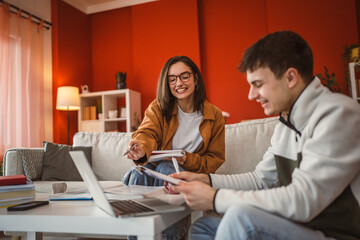 Wall Mural - two students man and woman use laptop for prepare exam at home