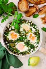 Wall Mural - Green shakshuka with feta, pesto and crispy bread.traditional moroccan dish. selective focus. hugge style