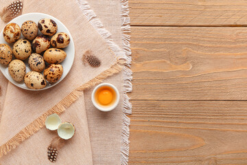 Wall Mural - Plate with fresh quail eggs and feathers on wooden background