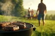 © top images - Man is grilling meat on a barbecue grill in a grassy field