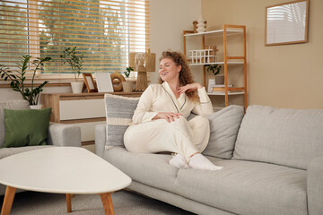 Wall Mural - Beautiful young woman relaxing on sofa at home. Day off concept